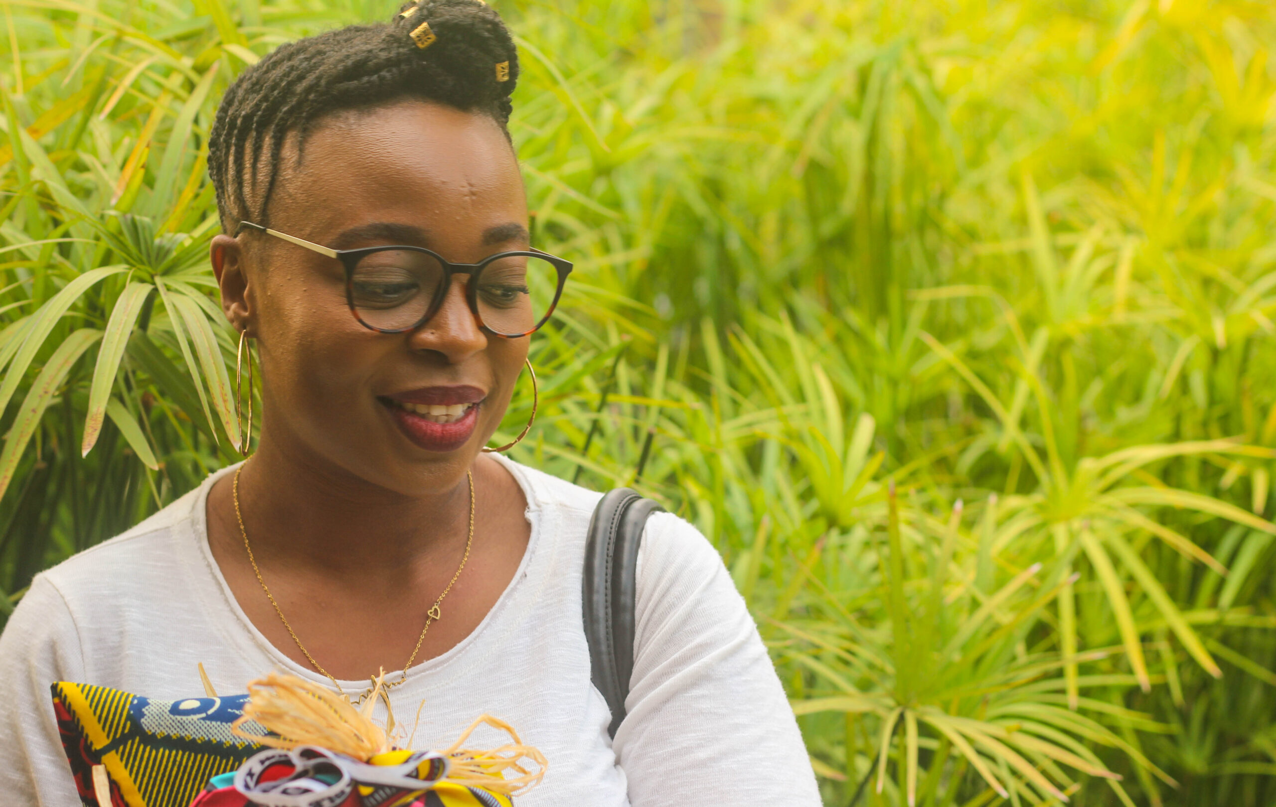 une femme et derrière elle un arrière plan avec de la végétation